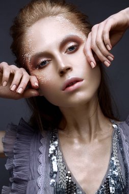 Yaratıcı makyaj ve yüzündeki dokular ile genç kız. Lila elbise ile güzel model parıldıyor