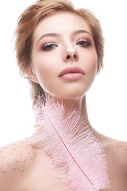 Genç kız makyaj çıplak ve pembe tüy elinde. Nazik bir manikür ile güzel model