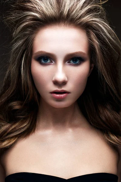 Ein junges Mädchen mit einem kreativen hellen Make-up und einer üppigen Frisur. schönes Modell mit Smokies. Schönheit des Gesichts. — Stockfoto