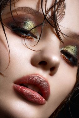 Parlak yaratıcı makyaj ve mükemmel cilt ile genç bir kız. Yüzünde ıslak saçlı güzel model. 