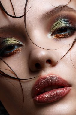 Parlak yaratıcı makyaj ve mükemmel cilt ile genç bir kız. Yüzünde ıslak saçlı güzel model. 
