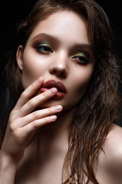 Parlak yaratıcı makyaj ve mükemmel cilt ile genç bir kız. Yüzünde ıslak saçlı güzel model. 