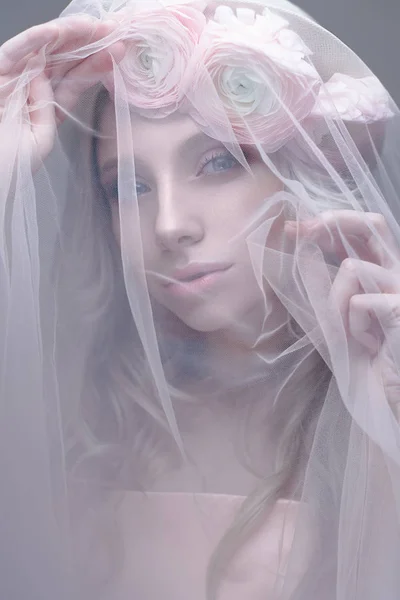Молодая девушка в образе невесты с вуалью на лице. Красивая модель с венком из цветов на голове — стоковое фото