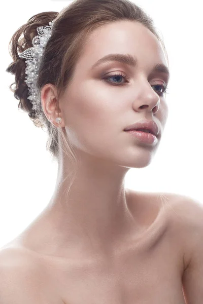 Ein junges Mädchen in einem sanften Hochzeitsbild mit einem Diadem auf dem Kopf. schönes Modell im Bild der Braut auf weißem Hintergrund mit Nude-Make-up. reine, glänzende Haut. — Stockfoto