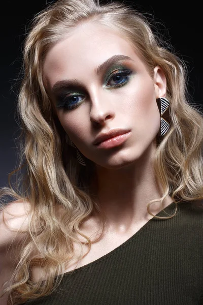 곱슬 머리와 밝은 창조적인 메이크업 어린 소녀입니다. 귀걸이 녹색 상단에 아름 다운 모델입니다. 얼굴의 아름다움. — 스톡 사진