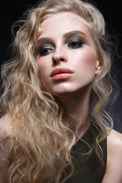 곱슬 머리와 밝은 창조적인 메이크업 어린 소녀입니다. 귀걸이 녹색 상단에 아름 다운 모델입니다. 얼굴의 아름다움. — 스톡 사진