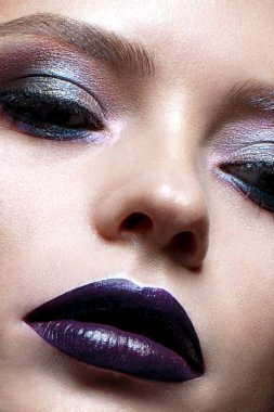 Yaratıcı makyaj ile genç kız. Güzel bir model parlak gözleri ve mor dudaklar. Parlayan cilt