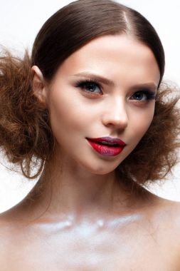 Yaratıcı parlak makyaj ve parlayan cilt ile genç kız. Güzel model bir saç modeli, gözleri ve kırmızı dudaklar okları ile. Yüz güzelliği