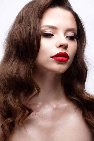 A young girl with a Hollywood wave and classic makeup. Beautiful model with red lips and arrows on eyes. Evening makeup and hairstyle. — Stock Photo, Image