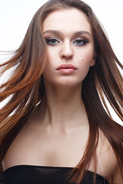 Una joven con un maquillaje clásico suave y cabello suelto. Hermosa modelo con maquillaje desnudo y cabello liso. Belleza de la cara y piel brillante — Foto de Stock