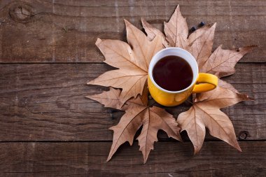 Fincan çay ve yaprakları rustik ahşap arka plan üzerinde