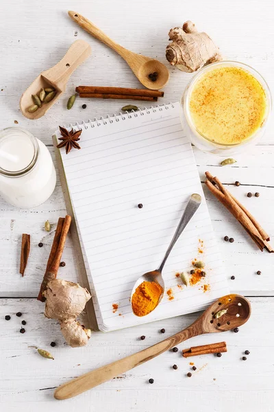 Latte de cúrcuma dorado en un vaso y especias —  Fotos de Stock