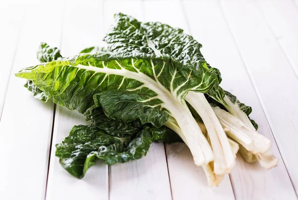 Stelletje silverbeet op een witte houten tafel — Stockfoto