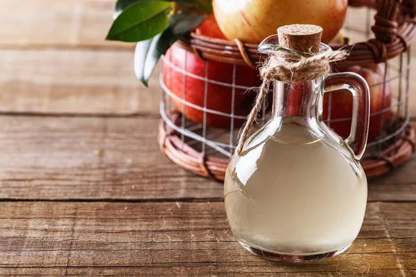 Apple cider vinegar over rustic wooden background — Stock Photo, Image