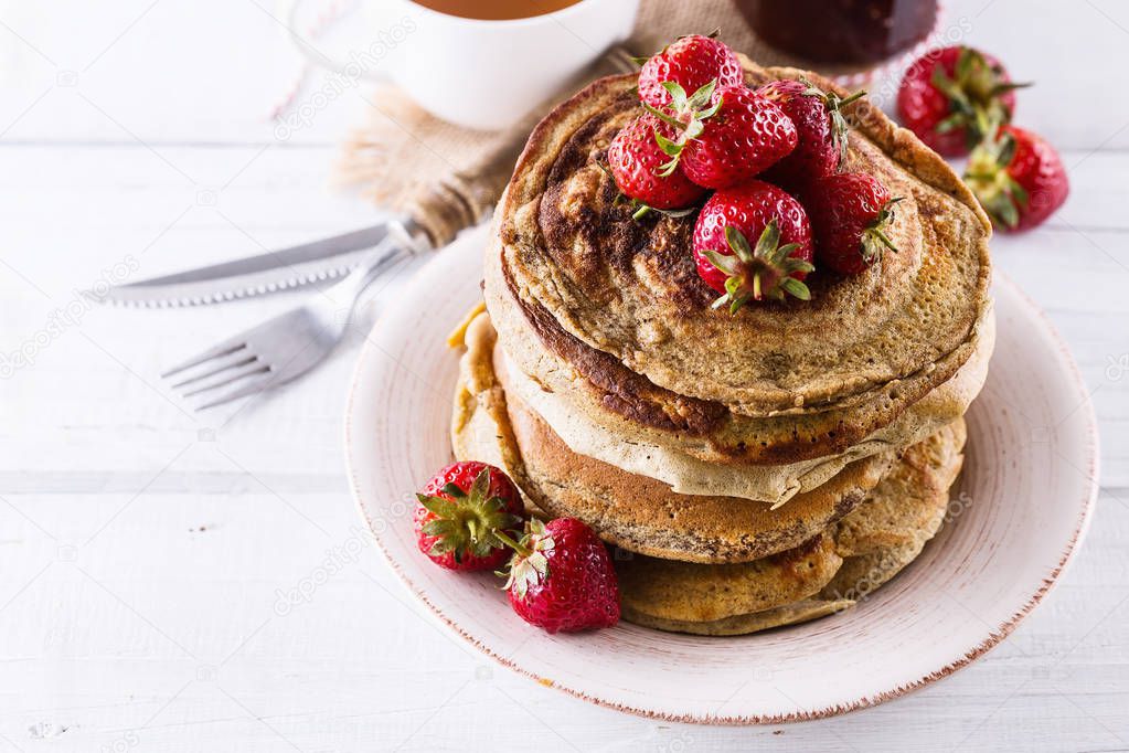 Pancakes over white wooden background