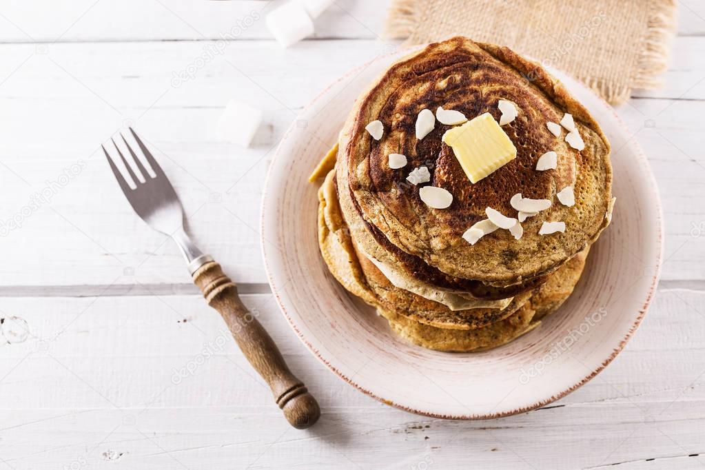 Pancakes over white wooden background