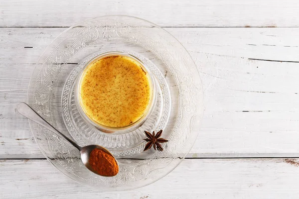 Top view image of turmeric latte over white wooden table Stock Photo