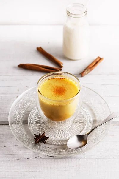 Gyllene latte över vitt trä bord Royaltyfria Stockfoton