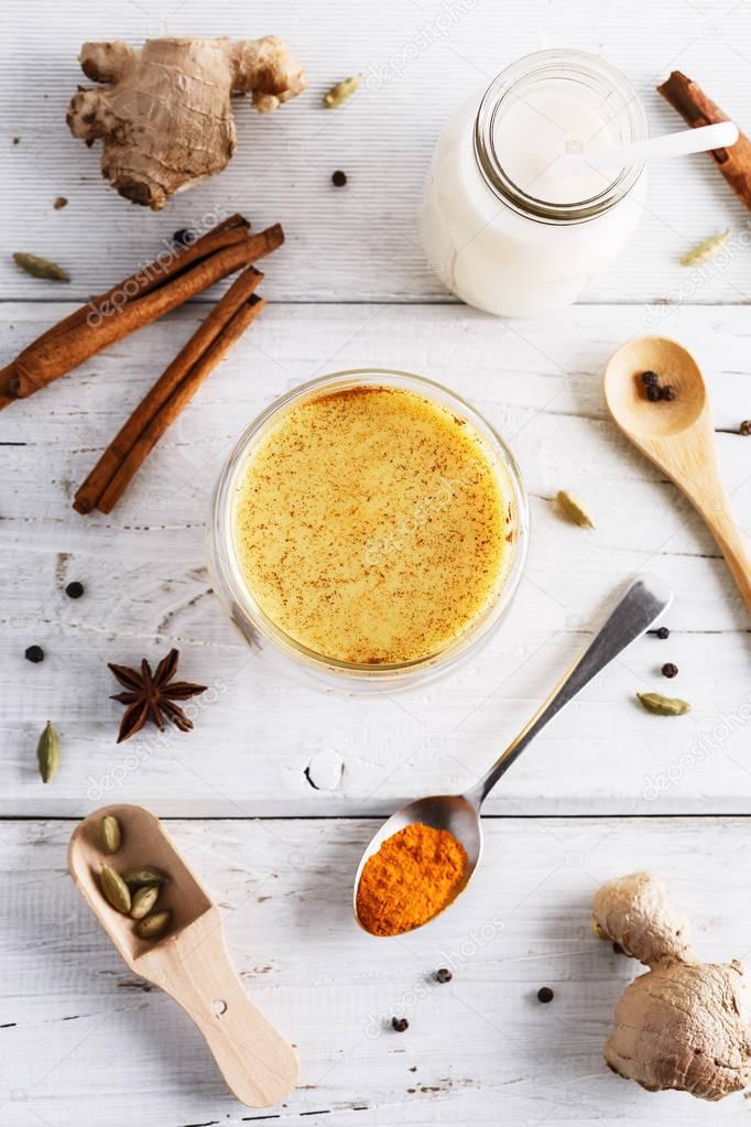 Top view image of turmeric latte over white wooden table