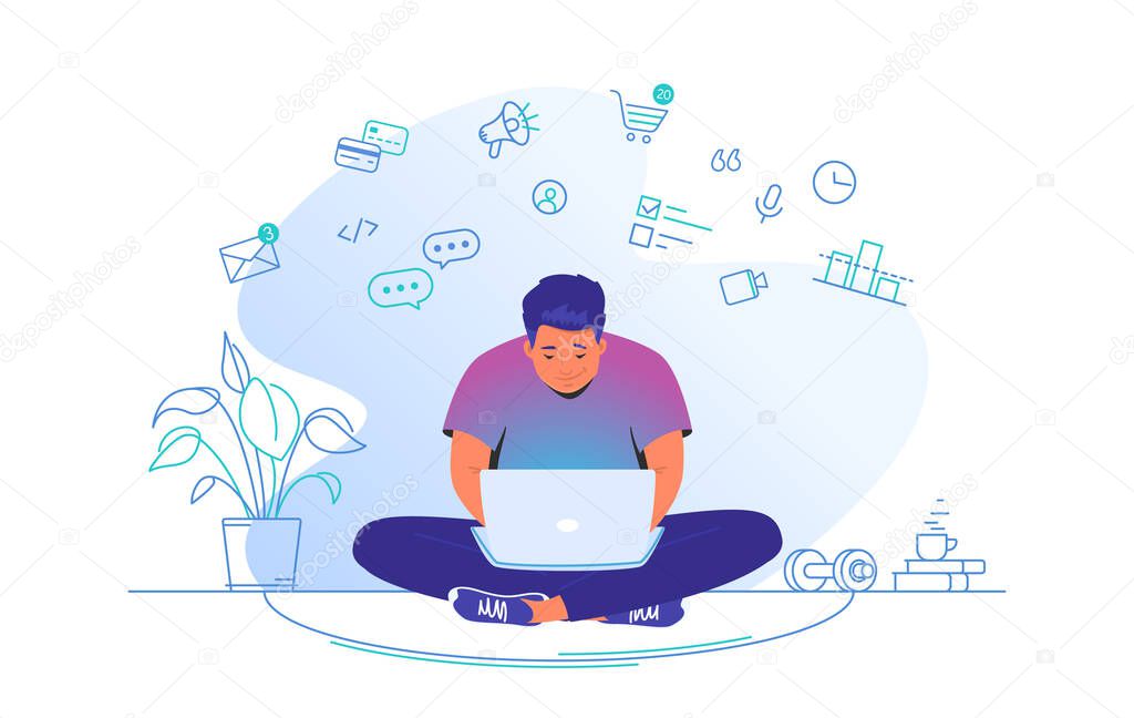 Working online with laptop at home. Cute man sitting at home in lotus pose with laptop and working remotely