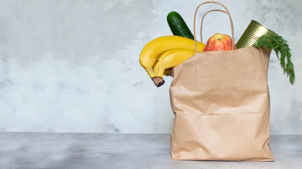 Food delivery banner. Delivery of fruits, vegetables and long-term storage products. An actual problem during quarantine and self-isolation. Kraft bag with food. Donations. Copy space. Mock up