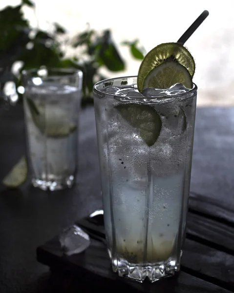 用猕猴桃冰和石灰冰软饮料 玻璃杯里的碳酸柠檬水 为新鲜的饮料的广告 净空纵向方向 — 图库照片