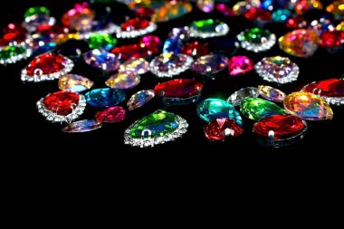 Siyah kumaş üzerinde çok renkli yapay elmaslar