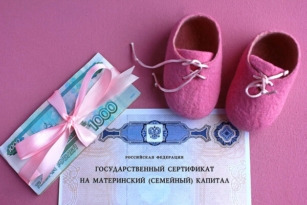 Russia January 17, 2020. Text: Russian Federation State certificate for maternal (family) capital. Russian money and pink baby booties