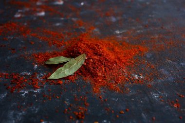 Kara masa ve kırmızı rendelenmiş toprak küçük Kore acı biberi ve baharatlı yemeklerde aroma ve baharat için defne yaprağı.