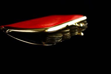 İçinde para olan altın sikkelerle dolu kırmızı, klasik, siyah arka planda.