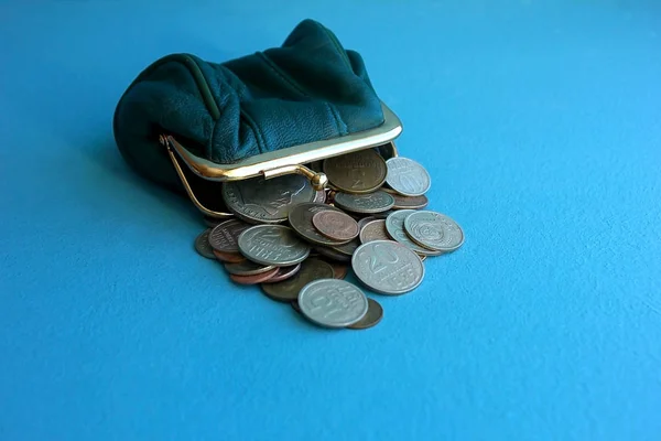 Old conscientious copper penny coins in a vintage green purse on a blue-green background. Numismatics