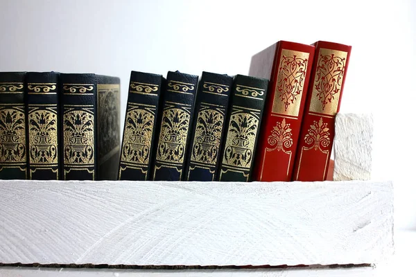 A collection of books is on the Book row in a white wooden box on a white background design in a light style
