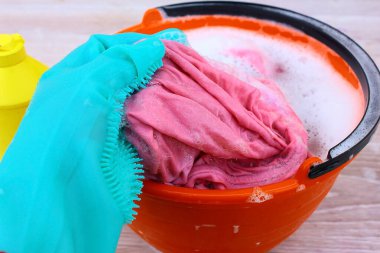 Plastik kırmızı kova, sabunlu su, mavi lastik eldiven ve bez. Yer temizleme ve ıslak temizlik ekipmanları..