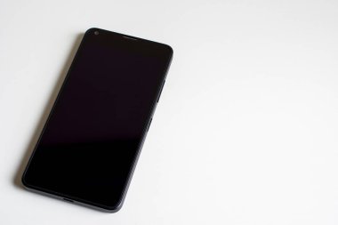 Beyaz masa zemininde boş ekran olan cep telefonu.