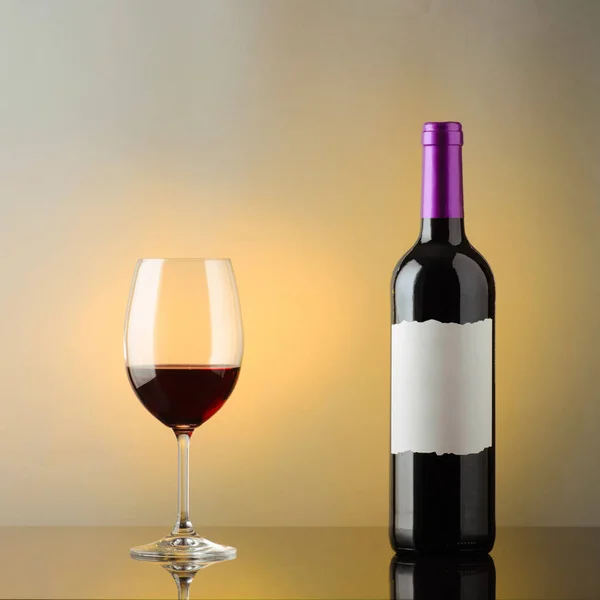 Una botella de vino tinto y una copa de vino —  Fotos de Stock