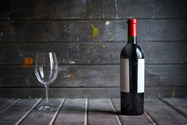 Eine Verstaubte Flasche Rotwein Und Ein Glas Vor Dem Hintergrund — Stockfoto