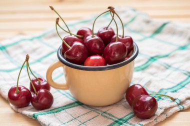 Kırmızı Kiraz sarı Kupası ve ahşap masa masa örtüsü ile