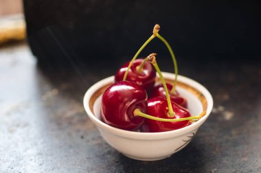 Kiraz beyaz tabak içinde güneş ışığı ile yaktı