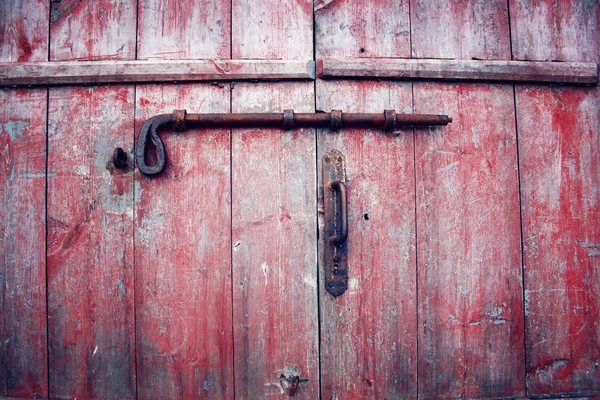 Old red barn doors with rusty bolt. Russian north.