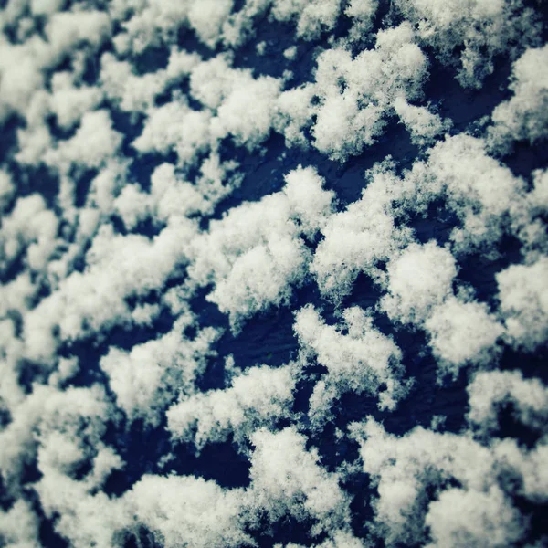 Pluizig sneeuwvlokken op het houten oppervlak. Winter. — Stockfoto