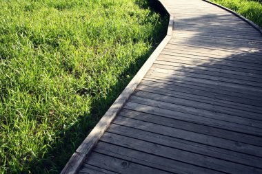Ahşap yolu bir bahar parkta. Yaşlı fotoğraf.