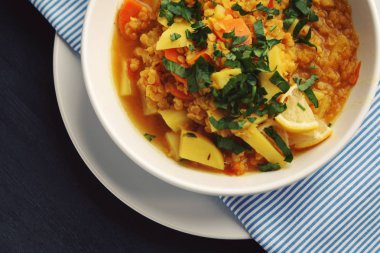 Kırmızı Mercimek Güveç yuvarlak beyaz tabakta. Üstten Görünüm