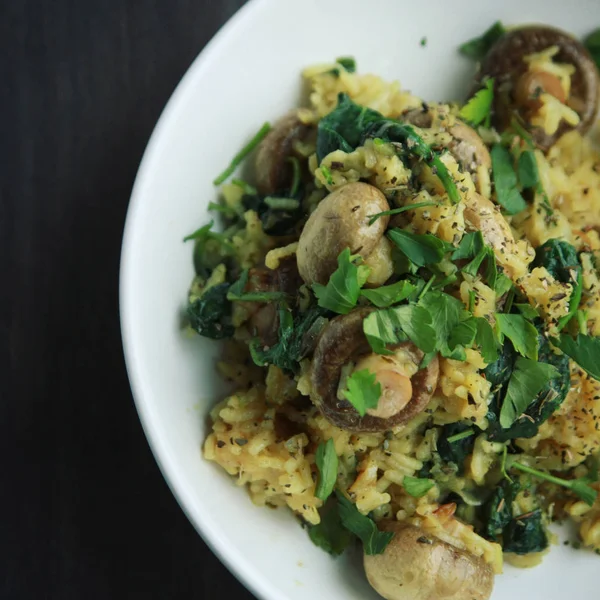 Riso giallo con funghi e spinaci. Piatto vegano — Foto Stock