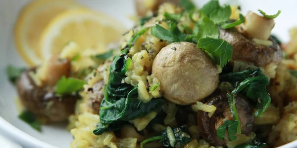 Riso giallo con funghi e spinaci. Piatto vegano — Foto Stock