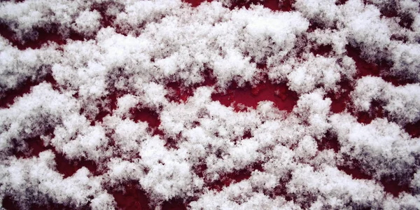 Superfície de madeira vermelha coberta de neve. Fechar . — Fotografia de Stock