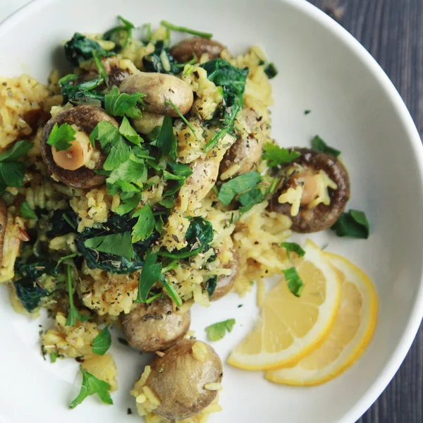 Riso giallo con funghi e spinaci. Piatto vegano — Foto Stock