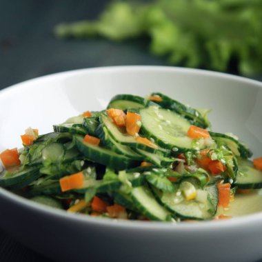 Beyaz tabakta Asya salatalık salatası. Yakın çekim.