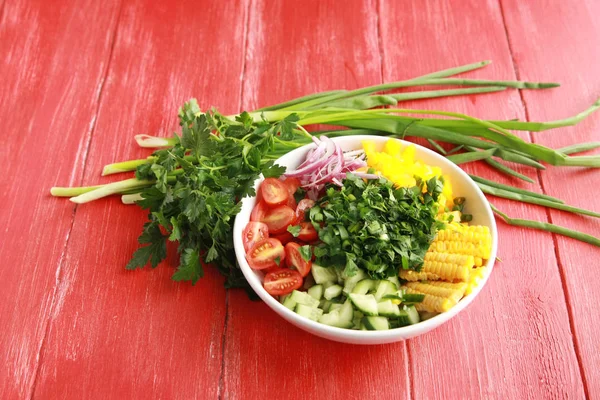 Witte plaat met gesneden groenten voor een vegan-salade. — Stockfoto