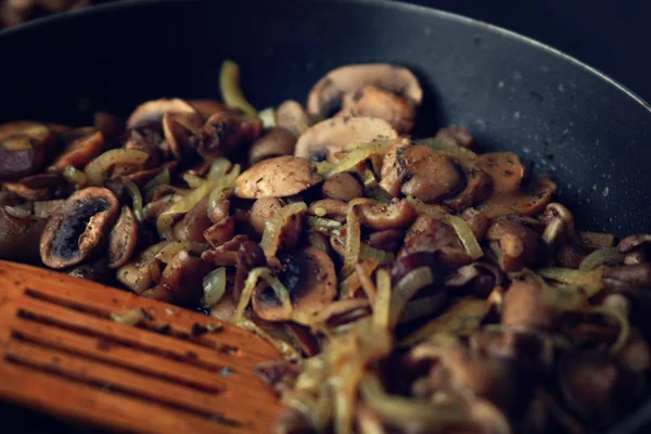 Fried mushrooms and onion in the frying pan.