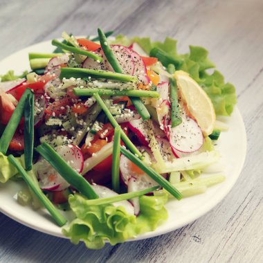 Bahar beyaz tabakta sebze salatası. Vegan.